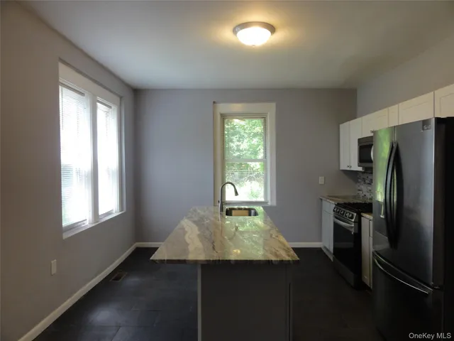 a kitchen that has a microwave and a refrigerator