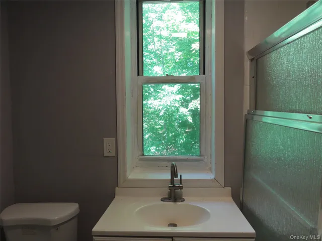 a bathroom with a toilet a sink and window