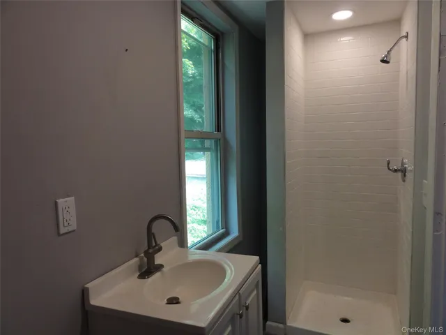 a bathroom with a sink a mirror and shower