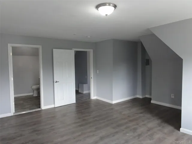 an empty room with wooden floor & windows