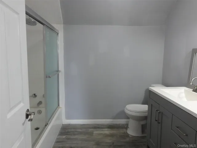 a bathroom with a granite countertop toilet and a sink