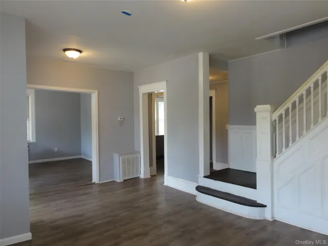 a view of a hallway with wooden floor and entryway