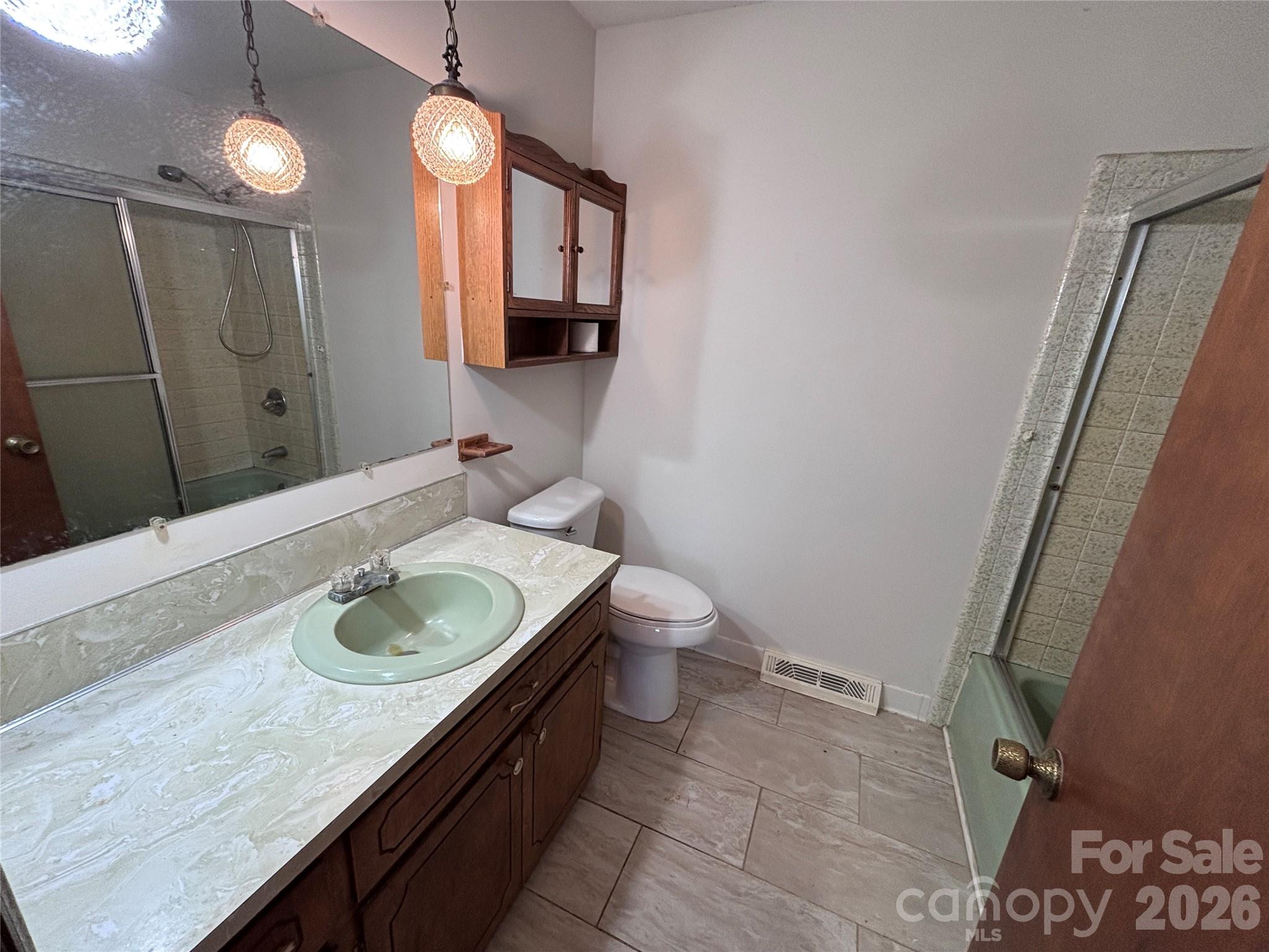 14740 Hatley-Burris Road Oakboro, NC 28129 - Photo 19 of 24 a bathroom with a granite countertop sink a mirror and toilet