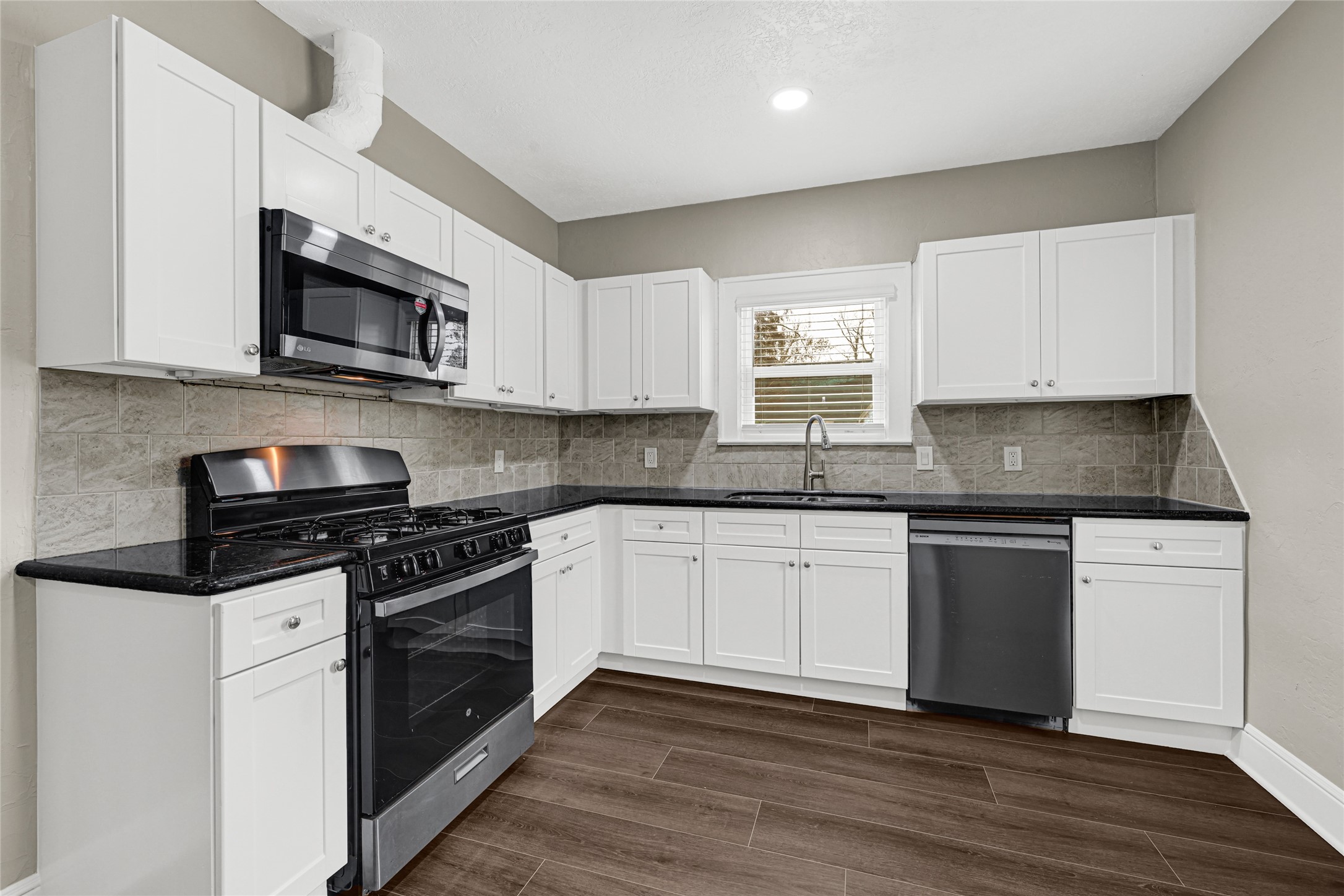 7403 Cayton Street Houston, TX 77061 - Photo 8 of 18 a kitchen with granite countertop wooden cabinets and a stove top oven