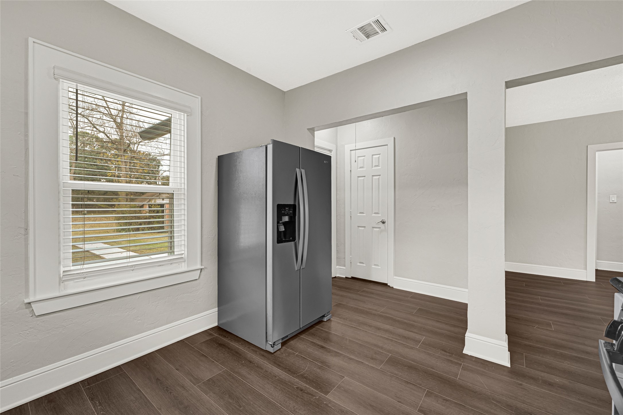 7403 Cayton Street Houston, TX 77061 - Photo 9 of 18 a view of an empty room with wooden floor and a window