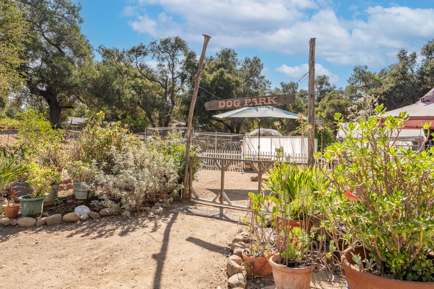 1273 South Rice Road, Unit 12 Ojai, CA 93023 - Photo 26 of 27 a view of a patio with table and chairs under an umbrella next to a road