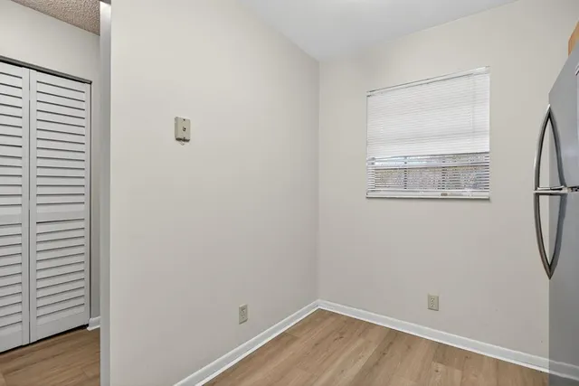 a view of a small space with wooden floor and a window