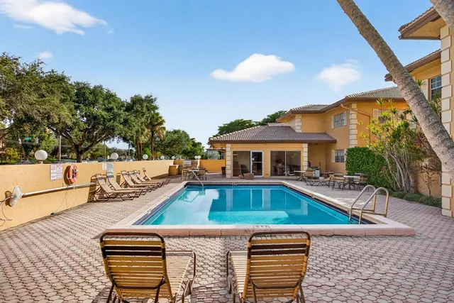 a view of a house with pool and chairs