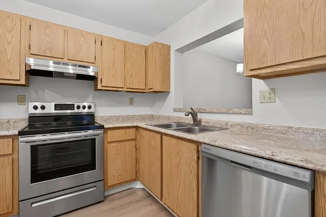 a kitchen with stainless steel appliances granite countertop a sink stove and cabinets