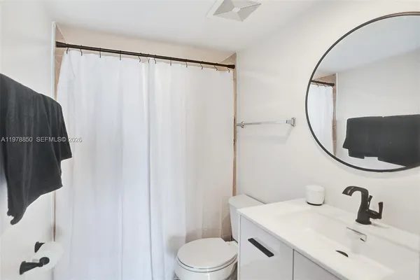 a bathroom with a sink vanity mirror and toilet