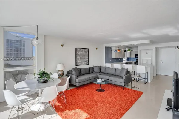 a living room with furniture a rug and a table