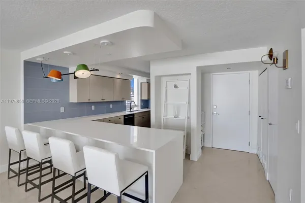a kitchen with stainless steel appliances kitchen island a table and chairs in it