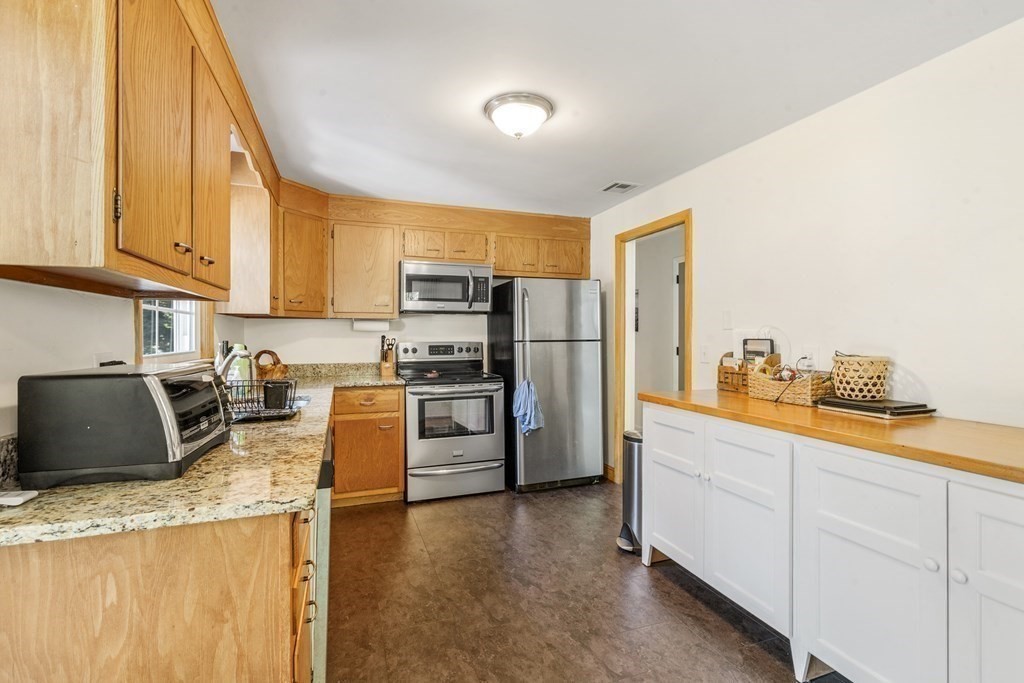 36 Putnam Road Bedford, MA 01730 - Photo 2 of 15 a kitchen with granite countertop a refrigerator sink stove and oven