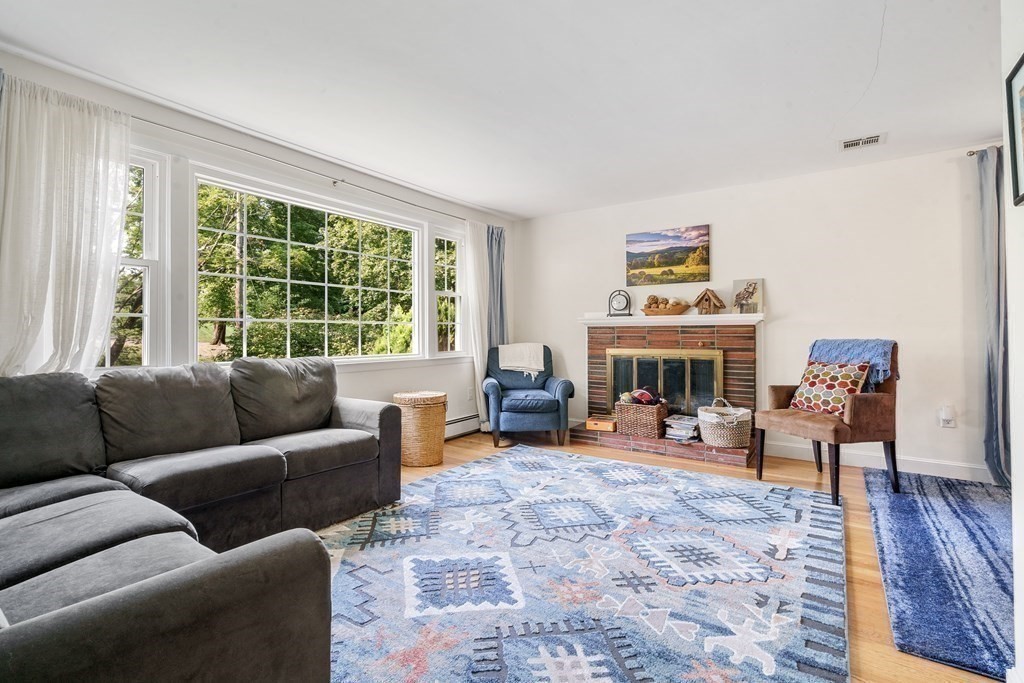 36 Putnam Road Bedford, MA 01730 - Photo 7 of 15 a living room with furniture large window and a fireplace