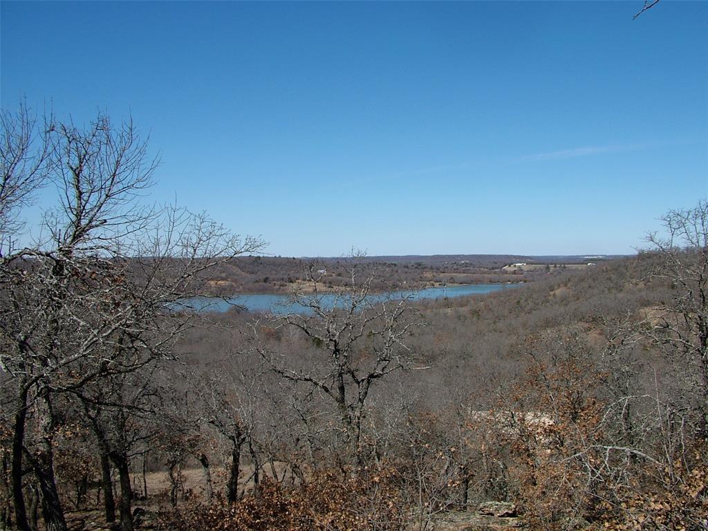 401 Mountainview Court Sunset, TX 76270 - Photo 2 of 18 a view of a dry yard with trees in the background