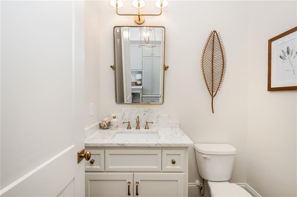 4184 Thompson Mill Road Buford, GA 30519 - Photo 30 of 53 a bathroom with a toilet a sink and mirror