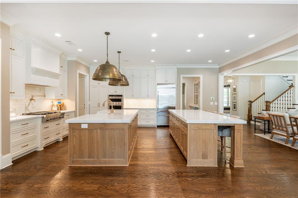 4184 Thompson Mill Road Buford, GA 30519 - Photo 3 of 53 a large kitchen with stainless steel appliances kitchen island granite countertop a large counter top a stove and a chandelier