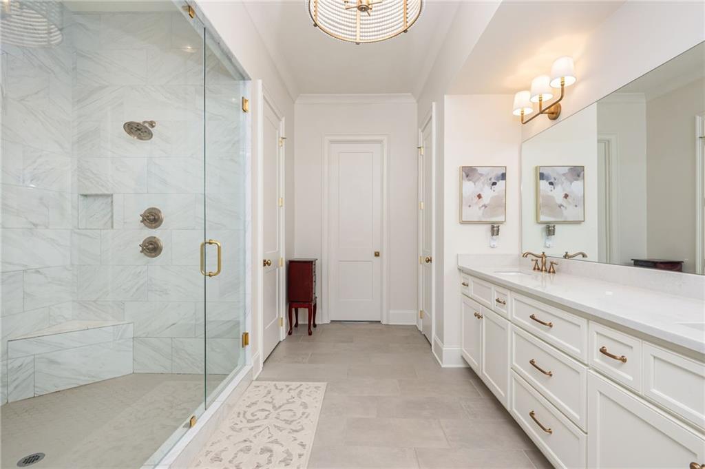 4184 Thompson Mill Road Buford, GA 30519 - Photo 41 of 53 a spacious bathroom with a granite countertop sink a mirror a shower and a bathtub
