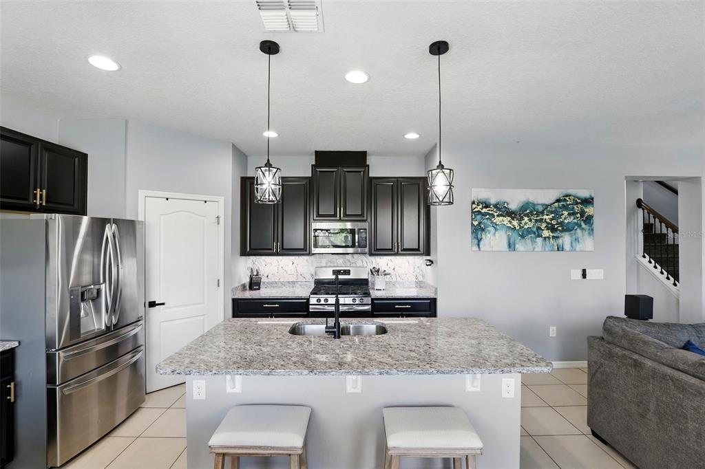 1338 Riley Circle Deland, FL 32724 - Photo 7 of 39 a kitchen with stainless steel appliances granite countertop a sink refrigerator and microwave