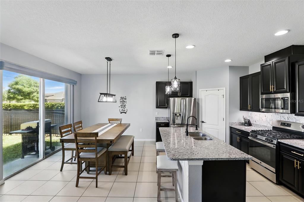 1338 Riley Circle Deland, FL 32724 - Photo 8 of 39 a open kitchen with stainless steel appliances kitchen island granite countertop a sink and cabinets