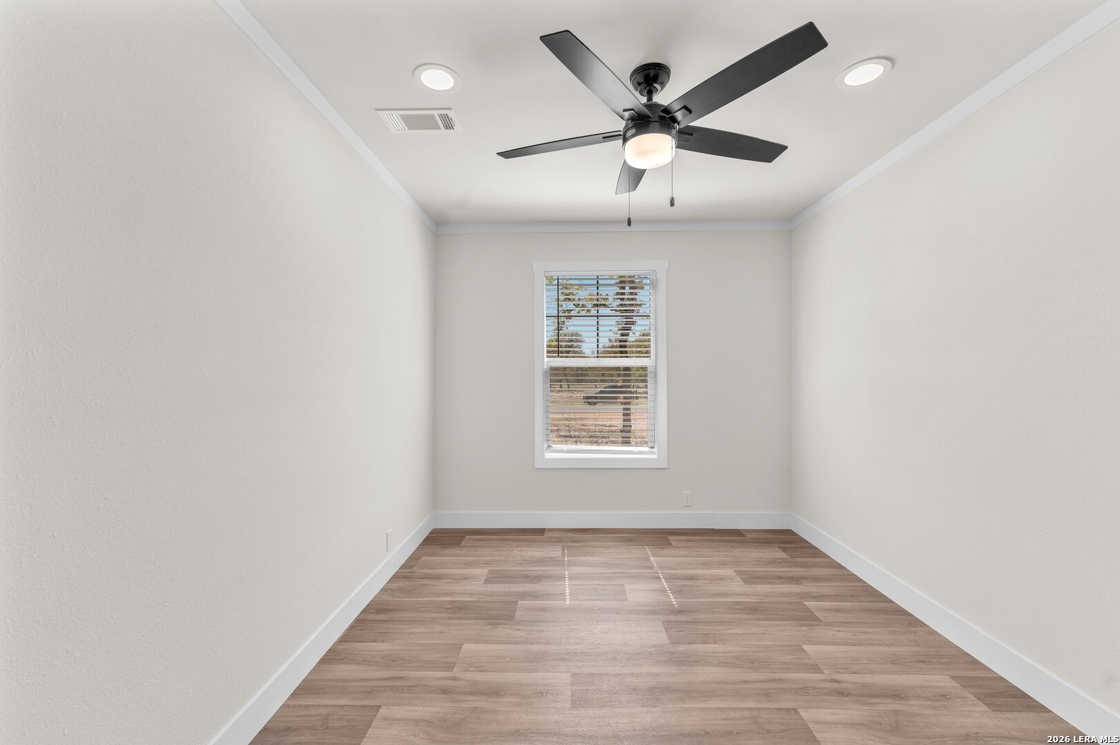 2218 Stevens Road Somerset, TX 78069 - Photo 17 of 24 an empty room with wooden floor and windows