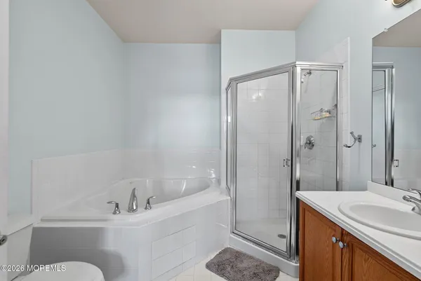 a bathroom with a bathtub shower sink vanity and toilet