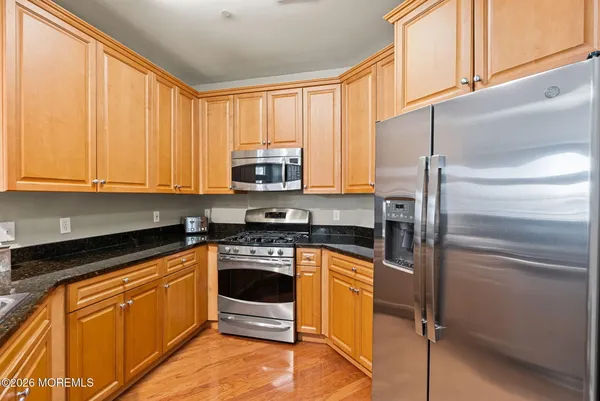 a kitchen with stainless steel appliances granite countertop a stove a refrigerator and a microwave