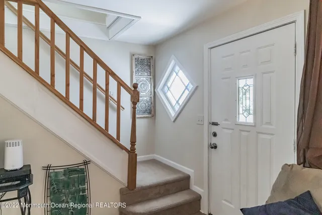 a view of an entryway with wooden floor and front door