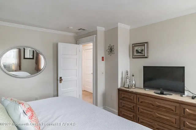 a bedroom with a flat screen tv and a bed