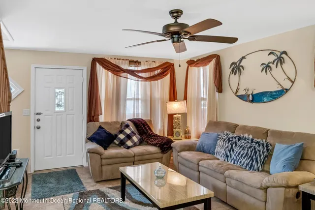 a living room with furniture a flat screen tv and a window