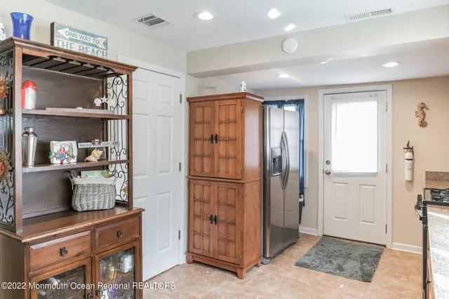 a view of kitchen with refrigerator and cabinets