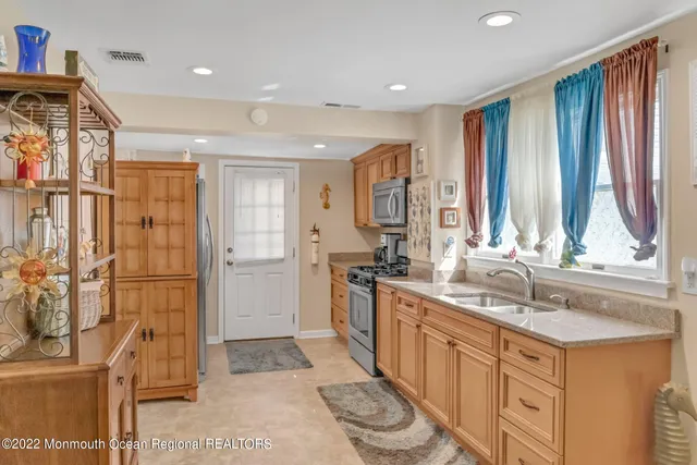 a kitchen with stainless steel appliances granite countertop a sink and a refrigerator