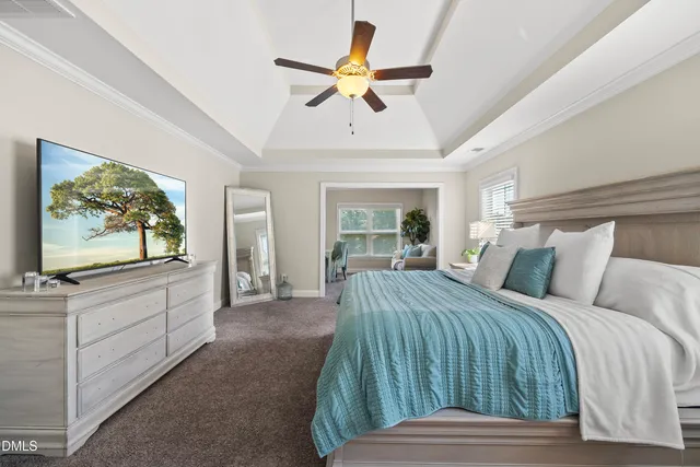 a spacious bedroom with a bed and a chandelier