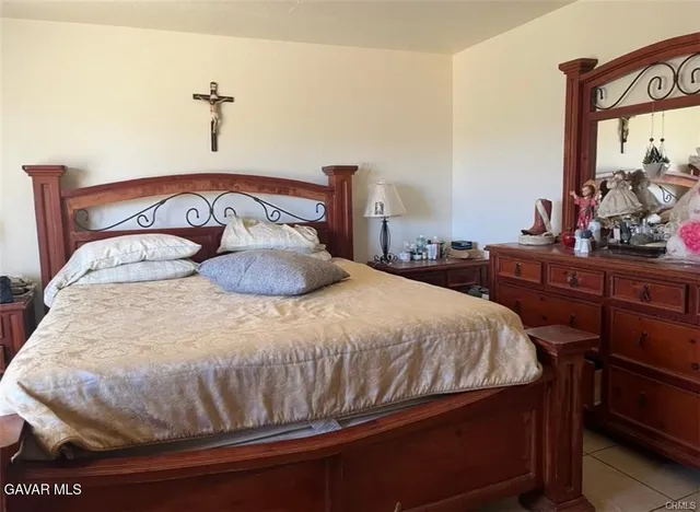 a bedroom with a bed and a flat tv screen on the dresser