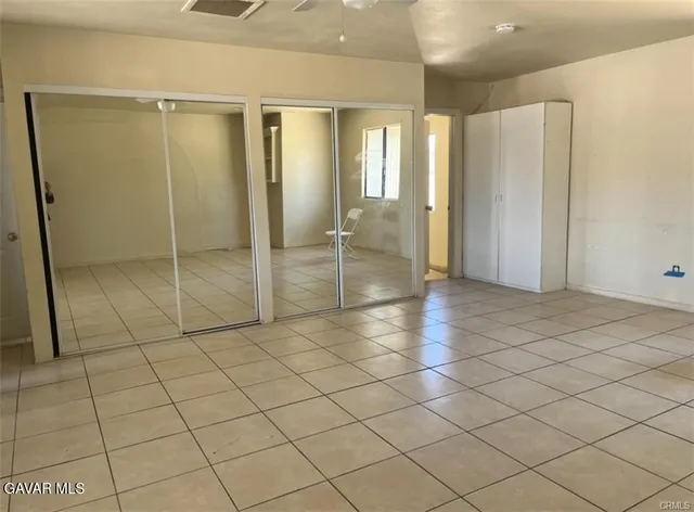 an empty room with cabinet and mirrors