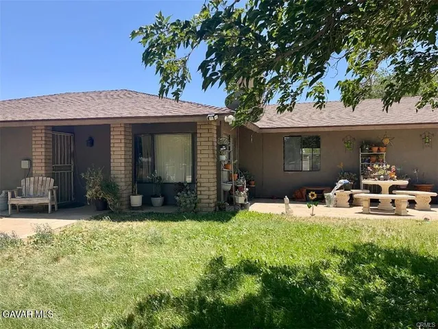 a view of a house with backyard porch and sitting area