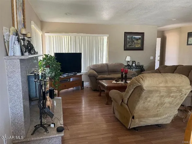 a living room with furniture a flat screen tv and a potted plant