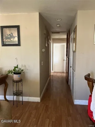 a view of a hallway to a livingroom with furniture and wooden floor