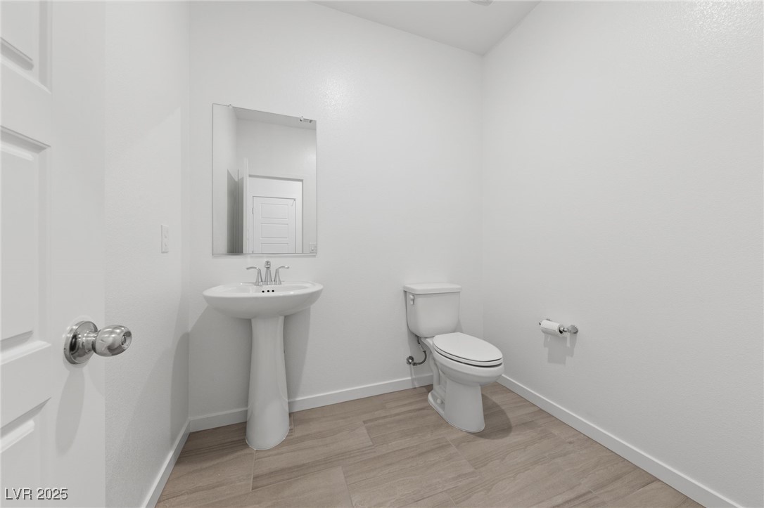 1561 Layla Crossing Avenue Henderson, NV 89002 - Photo 12 of 31 Bathroom featuring toilet and light wood-style floors