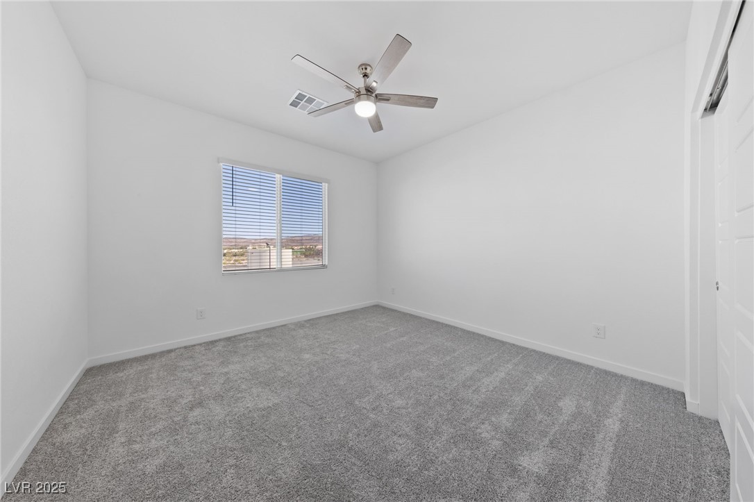 1561 Layla Crossing Avenue Henderson, NV 89002 - Photo 15 of 31 Unfurnished bedroom featuring light carpet, a ceiling fan, and a closet