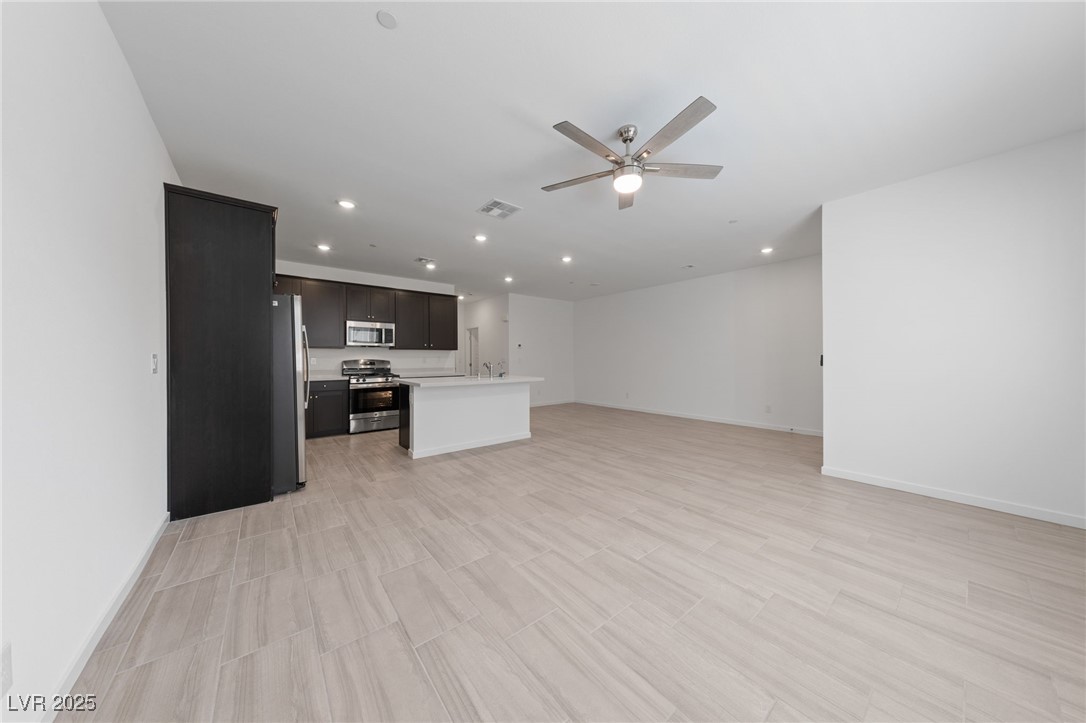 1561 Layla Crossing Avenue Henderson, NV 89002 - Photo 31 of 31 Kitchen with open floor plan, light countertops, an island with sink, stainless steel appliances, and recessed lighting