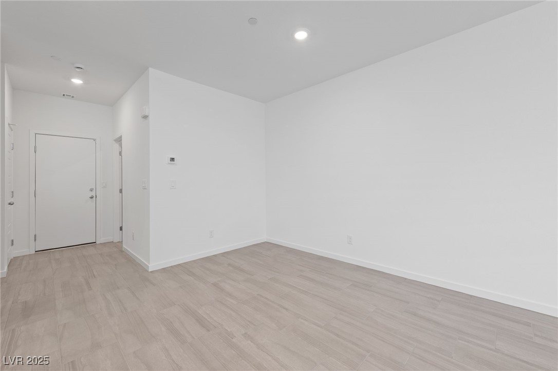 1561 Layla Crossing Avenue Henderson, NV 89002 - Photo 6 of 31 Empty room featuring light wood-type flooring and recessed lighting
