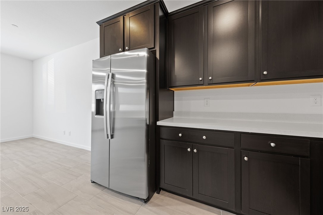 1561 Layla Crossing Avenue Henderson, NV 89002 - Photo 8 of 31 Kitchen featuring stainless steel refrigerator with ice dispenser and dark brown cabinets