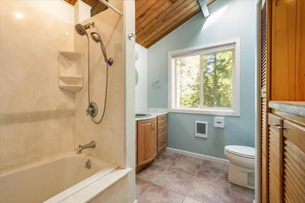 a bathroom with a granite countertop sink a toilet and a bathtub