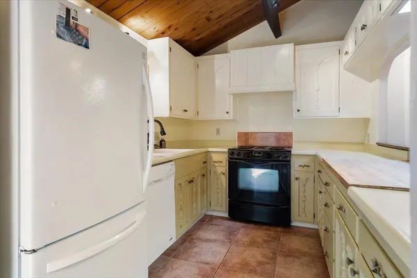 a kitchen with a stove sink and cabinets