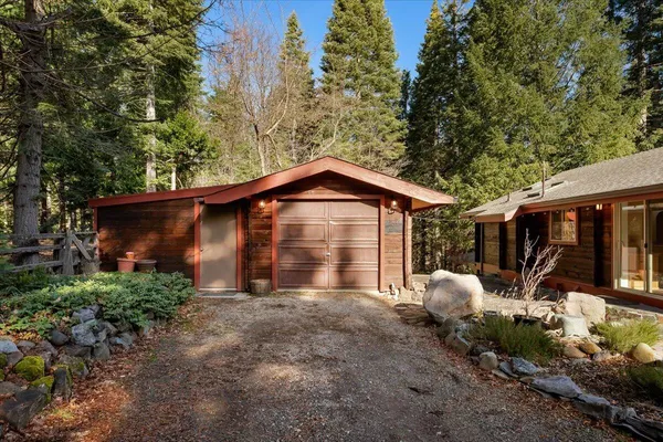 a view of a house with a yard and large trees