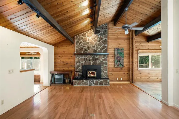 a view of a livingroom with wooden floor and a fireplace