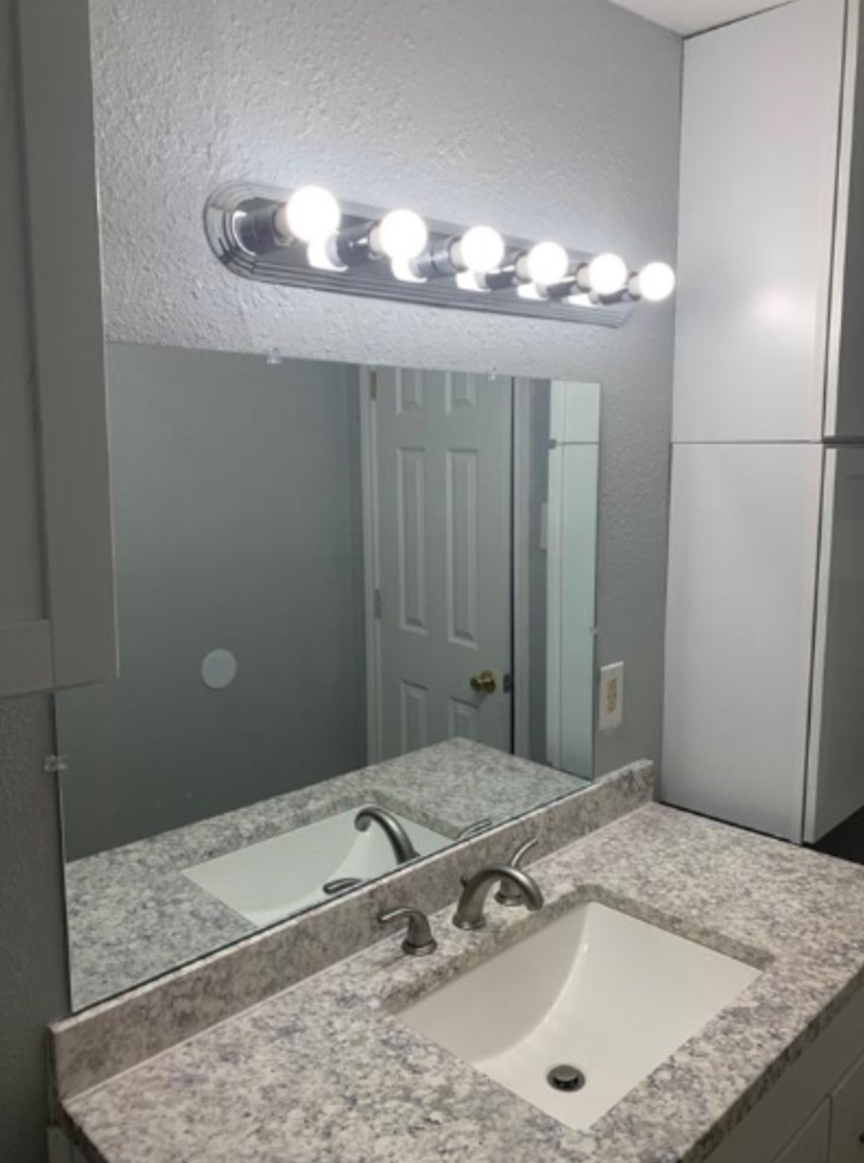 1015 Hackberry Street, Unit B San Marcos, TX 78666 - Photo 1 of 1 a bathroom with a granite countertop sink and a mirror