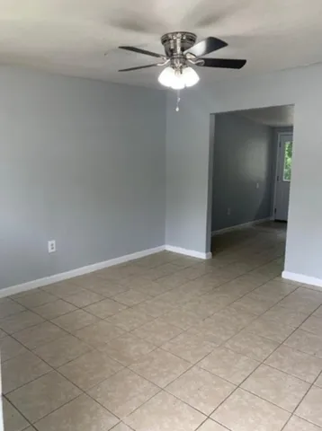 a view of an empty room with a chandelier fan