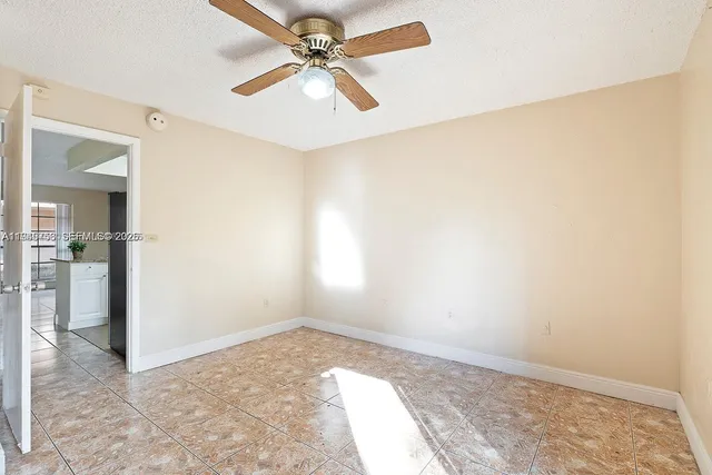 an empty room with a ceiling fan and a window